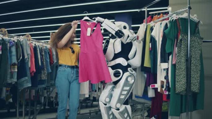 漂亮的女士在机器人的帮助下挑选衣服