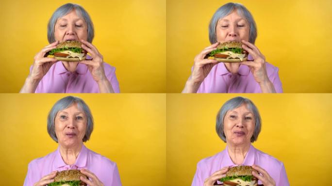 享受美味汉堡的老年妇女