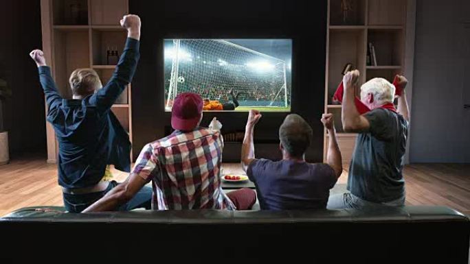 一群球迷正在电视上观看足球时刻并庆祝进球。