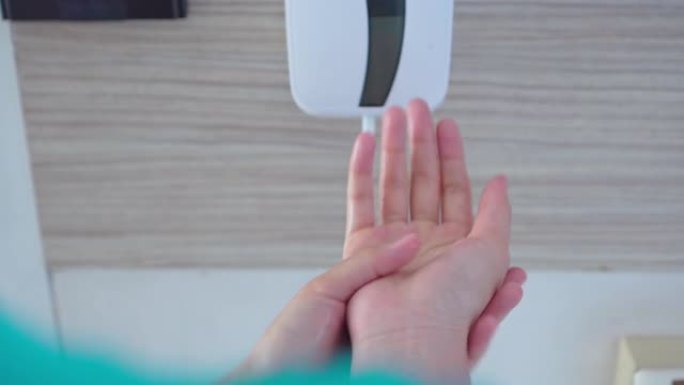 使用自动洗手液分配器预防感染的妇女