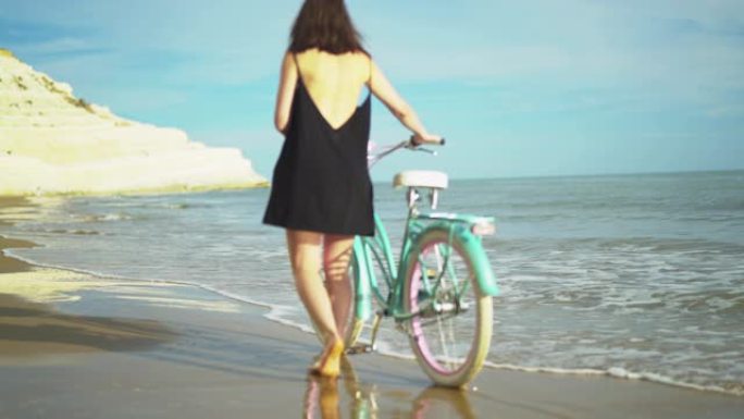 沙滩上骑自行车的女孩