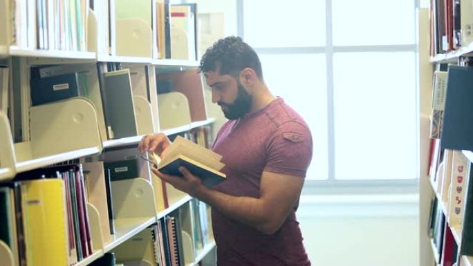 站在图书馆读书的中东男子