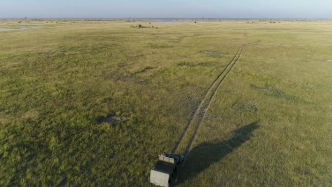 在博茨瓦纳的Makgadikgadi草原上行驶的野生动物园车辆和游客的4k高鸟瞰图