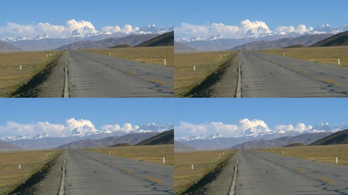 空旷的柏油路通向云层中雄伟的珠穆朗玛峰。