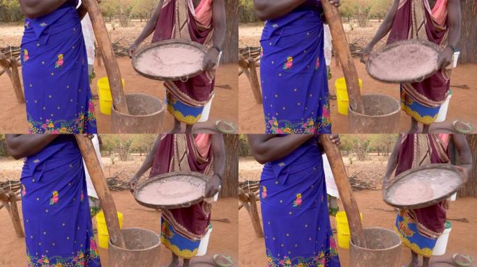 津巴布韦，用一种古老的传统方法筛选，捣碎和研磨高粱的三个女人的特写镜头