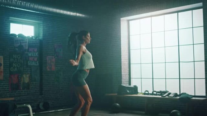 强壮的运动女性在阁楼风格的工业健身房用跳绳锻炼。她正在进行激烈的交叉健身训练计划。未能跳过绳子。