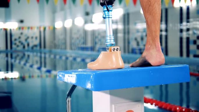 运动员在游泳池训练，穿着假肢，仿生设备。