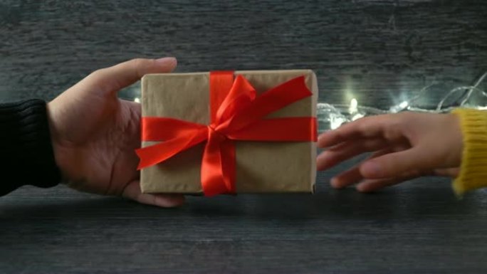 4k一个男人在情人节给一位女士一个礼品盒。