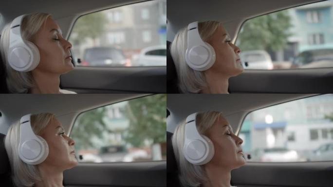 轻松的女人在开车时戴着耳机听音乐