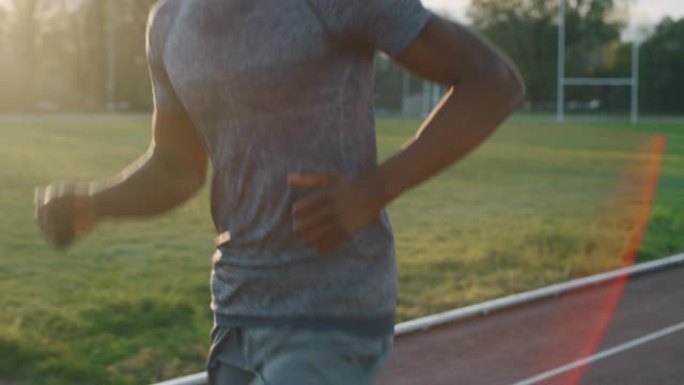 年轻的非洲男运动员的慢动作在体育馆的赛道上奔跑