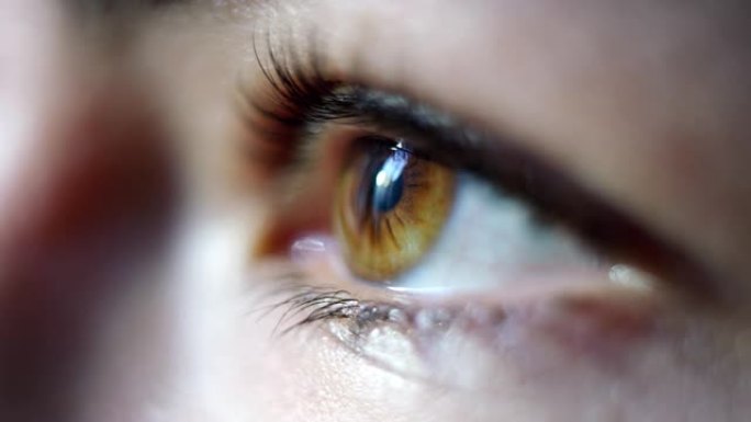 年轻女性棕色眼睛在慢动作中闪烁的特写微距镜头。