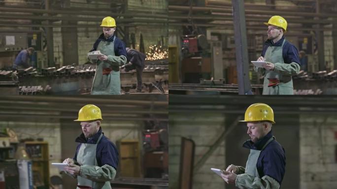 平板电脑在金属制造设施中行走的男性工程师