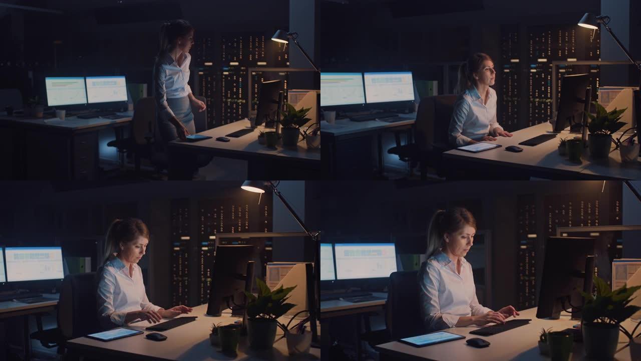 美丽的女商人肖像使用台式计算机，在键盘上打字，监视业务交易，签订合同。在大公司办公室工作到深夜