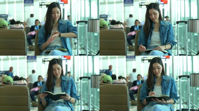 在航站楼机场的登机口等待和观看时间的年轻女性。年轻女性独自乘飞机旅行。