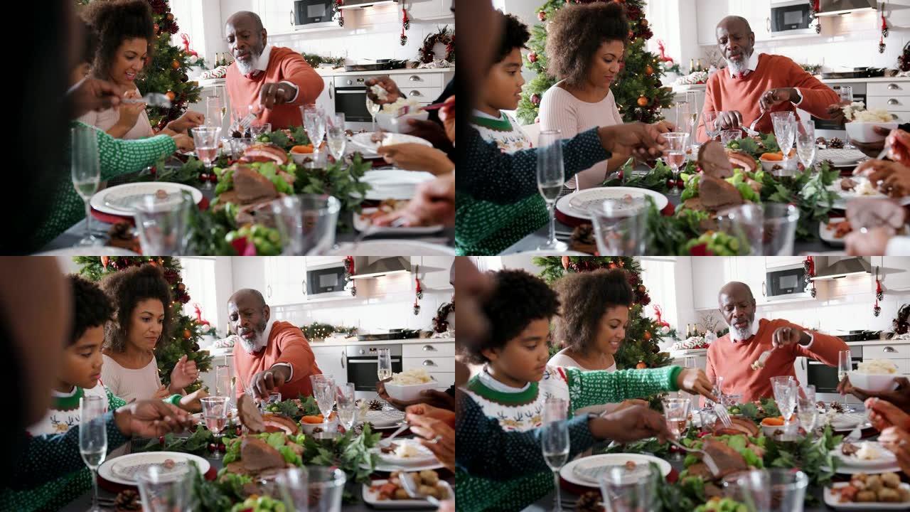 黑人多代家庭在圣诞节餐桌上为自己提供食物