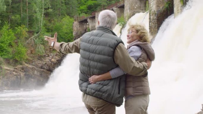 幸福的老年夫妇看着大坝溢洪道