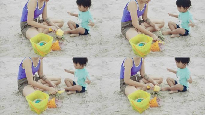 快乐男孩和母亲在沙滩上玩沙子和快乐