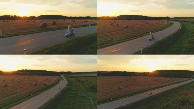 空中女子在日落时在乡下骑踏板车