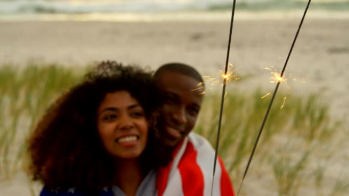 非裔美国夫妇在4k海滩手持烟火的前视图