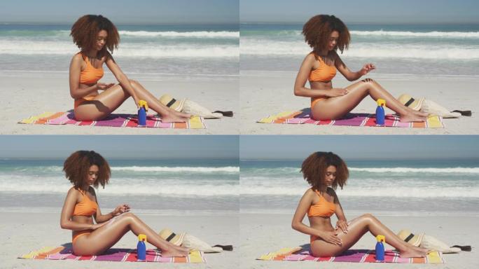 非裔美国妇女在海滩上使用防晒霜