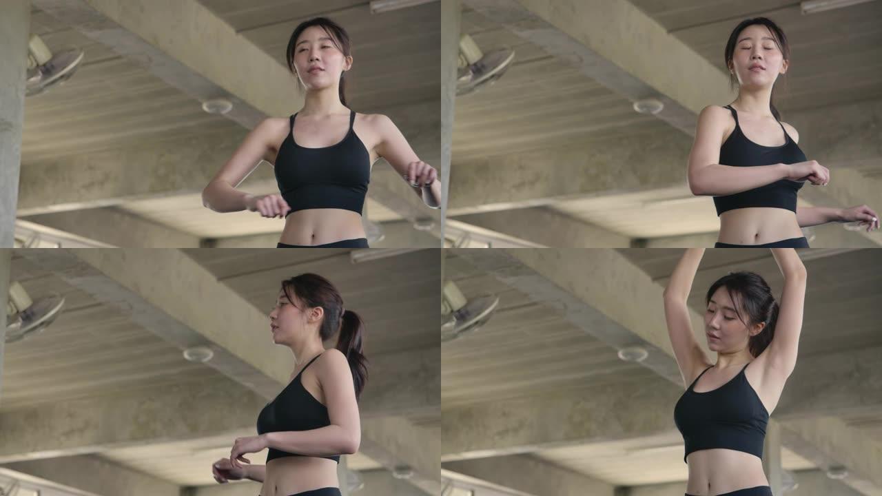 迷人的女人在健身房做伸展运动。年轻美丽的亚洲女人在运动锻炼前伸展双手热身。慢动作。医疗保健、运动和运