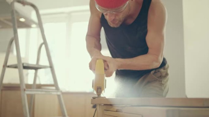 家庭自制。男人剪掉木制家具。