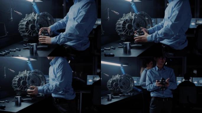 眼镜专业的汽车工程师正在使用计算机屏幕的高科技创新实验室中研究传动齿轮。
