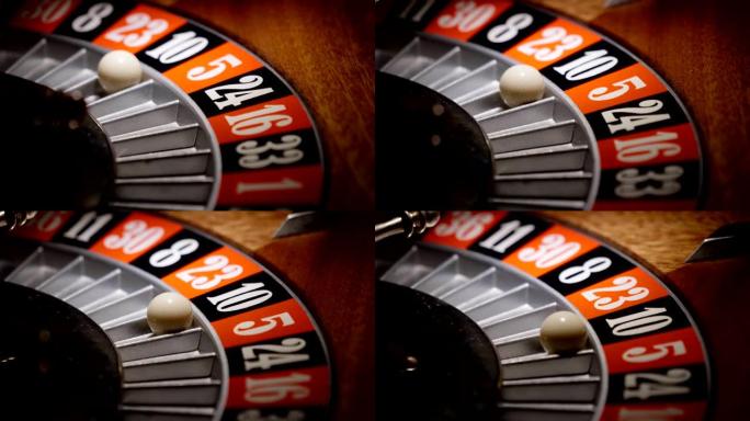 在赌场中轮盘赌的宏观拍摄，球进入绿色，红色或黑色数字。下注和下注的人可能赢得了丢失的徽章。