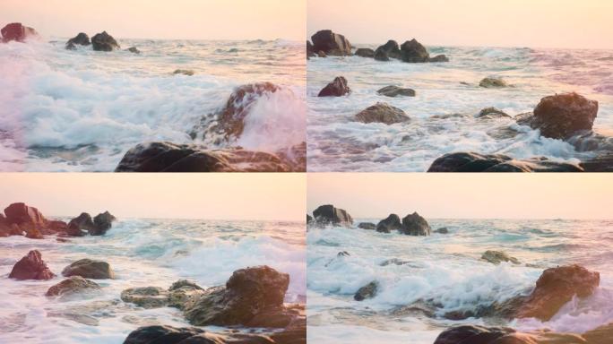 粉红色阴影的海浪在岩石上坠毁