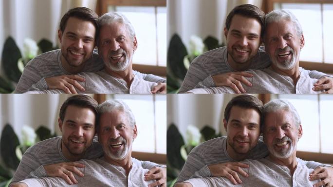 英俊的年轻人拥抱快乐的老父亲的肩膀。