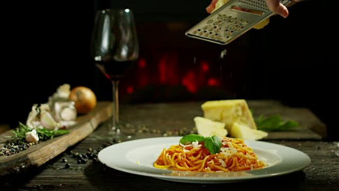 在刚酿造的盘子上慢动作烹饪磨碎的帕玛森奶酪，典型的意大利奶酪。