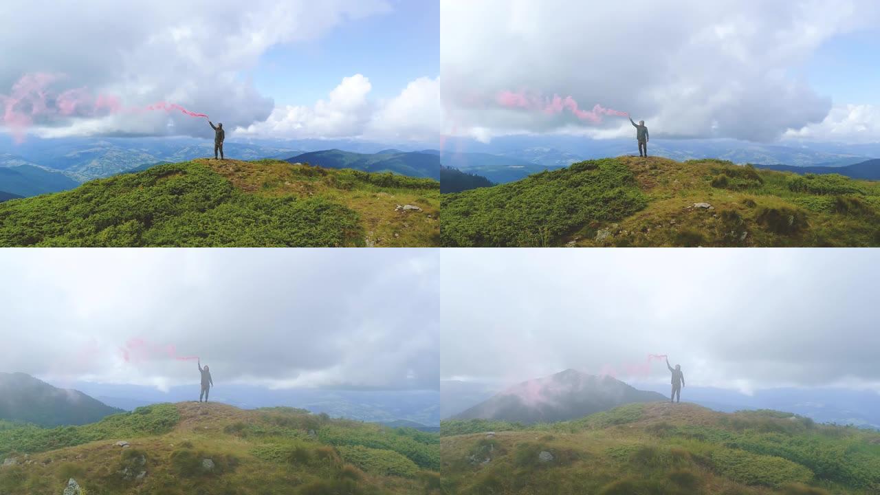 站在山顶上的带有彩色烟雾弹的雄性