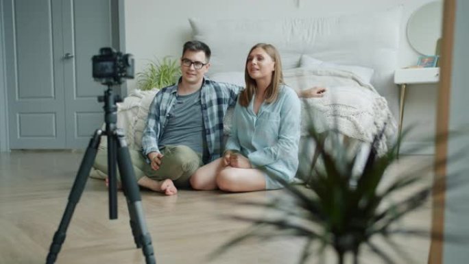 已婚夫妇博客作者在卧室里录制视频，显示竖起大拇指