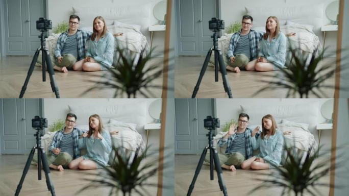 已婚夫妇博客作者在卧室里录制视频，显示竖起大拇指