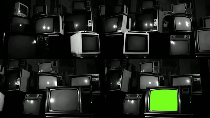 旧电视在一堆许多旧电视中打开绿色屏幕。黑白色调。