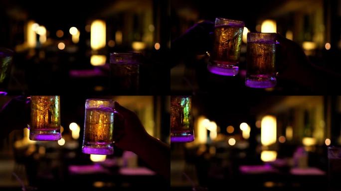 4k慢动作镜头烤啤酒和碰杯啤酒的特写镜头，在酒吧和餐厅一起欢呼，放松和喝酒的概念