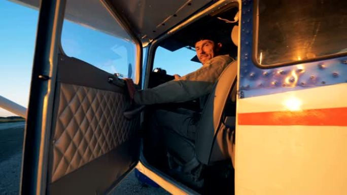 一个人坐在轻型飞机的驾驶舱里，特写镜头。