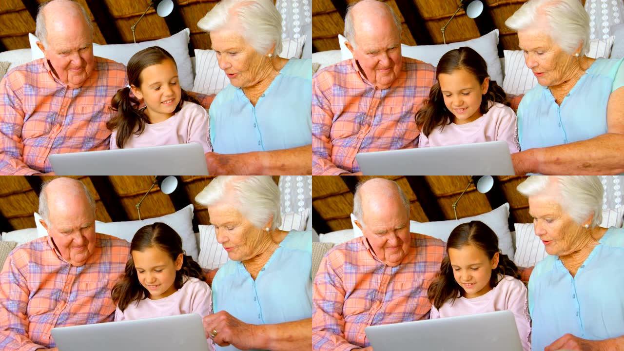 在舒适的家庭4k中使用笔记本电脑的高加索多代家庭的前视图