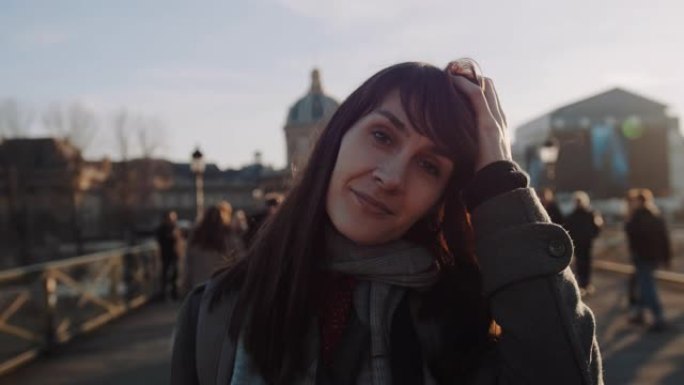 幸福美丽微笑的年轻女子的生活方式肖像在日落秋巴黎广场慢动作为相机摆姿势。