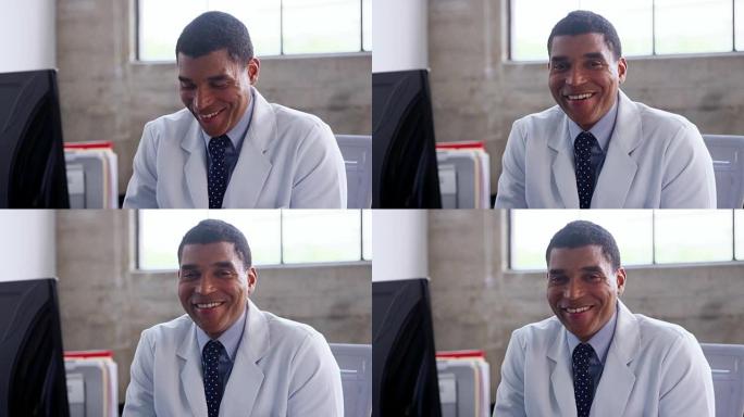 微笑的混血医生穿着实验室外套坐在办公室里