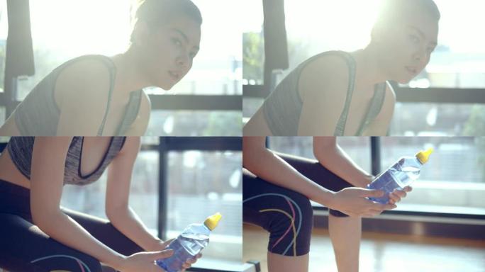 精疲力尽的年轻亚洲女性在健身房进行密集锻炼后休息