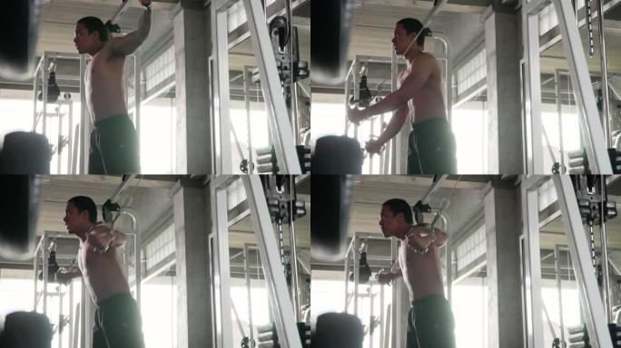 男子在健身房用举重机器锻炼