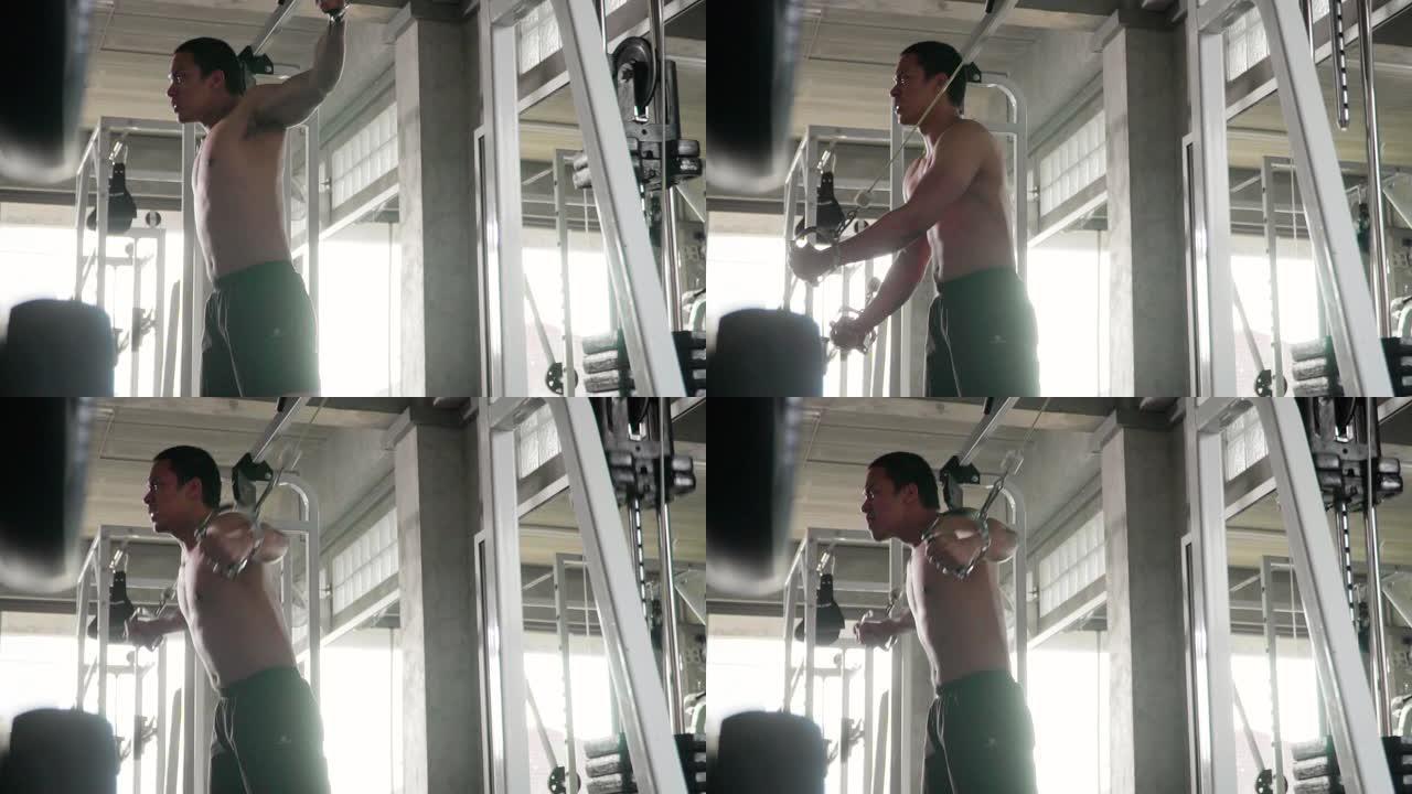 男子在健身房用举重机器锻炼