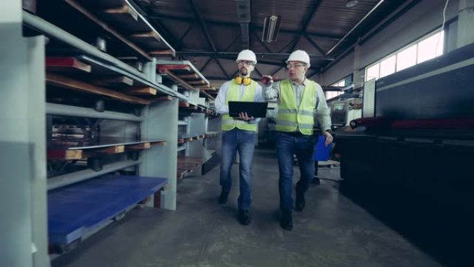 两名技术人员正沿着屋面材料厂行走