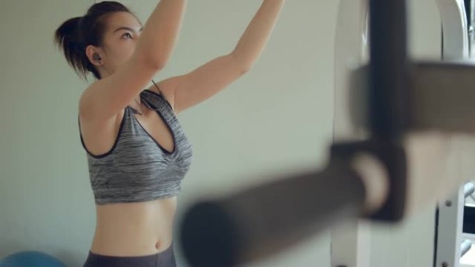 运动的年轻女子在家庭健身房用模拟器锻炼