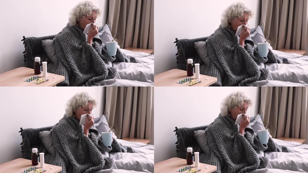 生病的老奶奶吹鼻子坐在床上感冒了