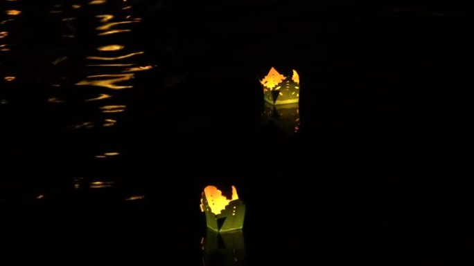 特写: 节日之夜，五颜六色的灯漂浮在宁静的河边。