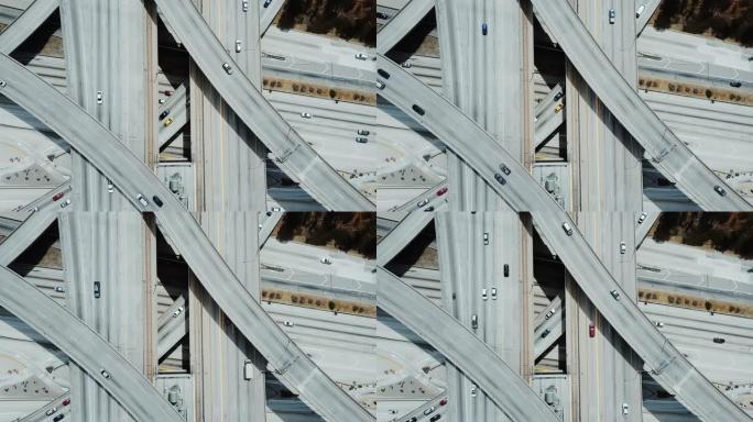 顶部视图史诗无人机锁定拍摄繁忙的高速公路交汇处，汽车穿过多层路口。