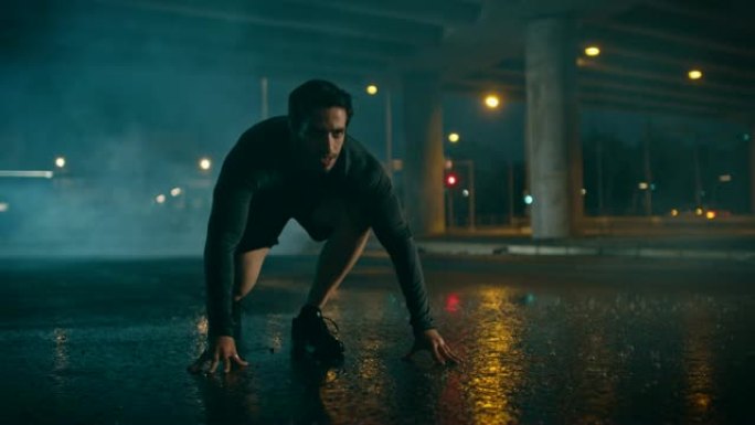 强壮的肌肉健康的年轻人在一个下雨的夜晚开始冲刺。他在城市环境中奔跑，背景是汽车。