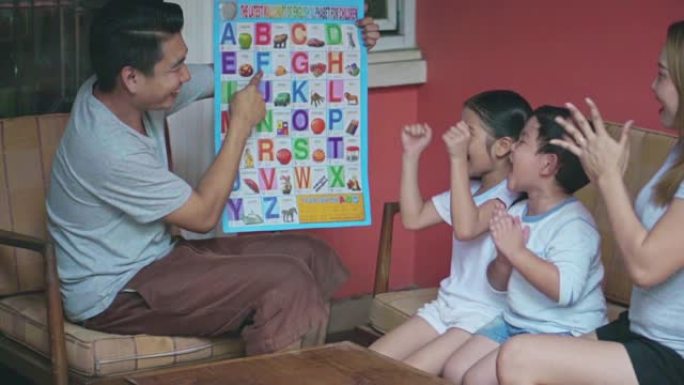 父亲正在教孩子阅读英语字母，慢动作